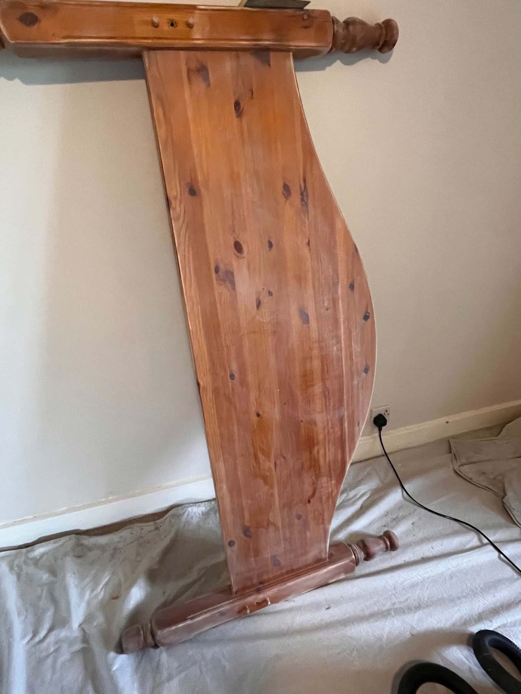 Bare pine bed frame before restoration